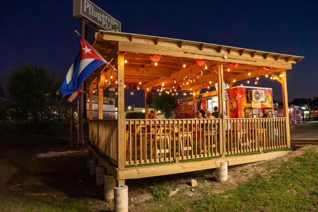 Terraza de 512 Pizzeria al atardecer con bandera cubana